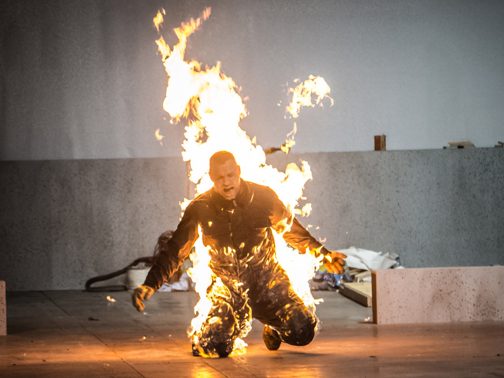 Person engulfed in flames during a controlled burn stunt demonstration